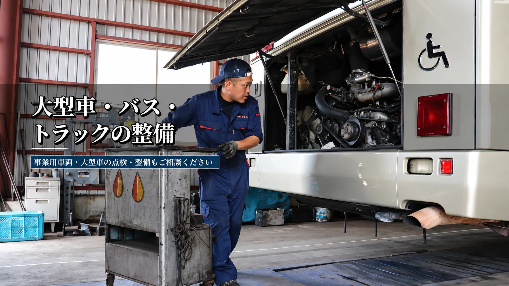 いまり整備センターの大型車・バス・トラック整備案内画像。整備士が大型車両の点検・整備を行っている様子。